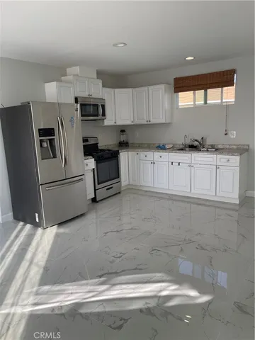 a kitchen with stainless steel appliances a sink a stove a microwave and cabinets