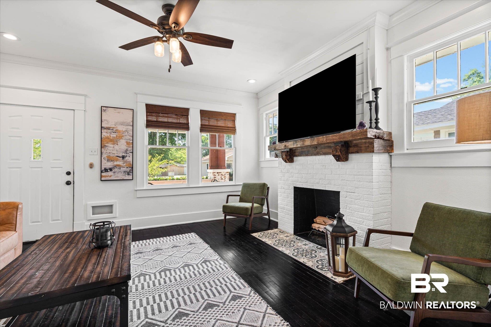 121 North Carlen Street Mobile, AL 36607 - Photo 4 of 21 Living room featuring dark wood-type flooring, a ceiling fan, a fireplace, and crown molding