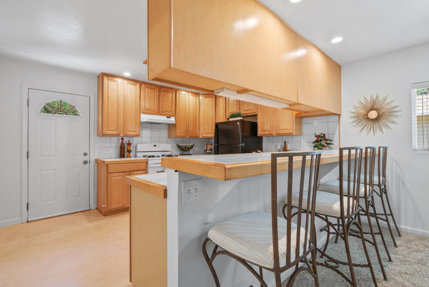 115 Shadowbrook Road Ben Lomond, CA 95005 - Photo 6 of 51 a kitchen with stainless steel appliances kitchen island granite countertop a refrigerator a stove a microwave oven with white cabinets and wooden floor