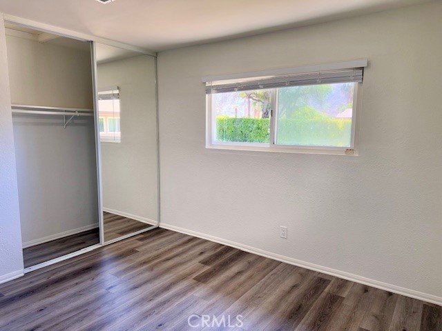 73740 Santa Rosa Way, Unit E Palm Desert, CA 92260 - Photo 10 of 15 a view of an empty room with wooden floor and a window
