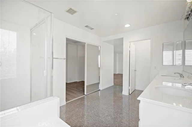a large white bathroom with a tub sink and mirror