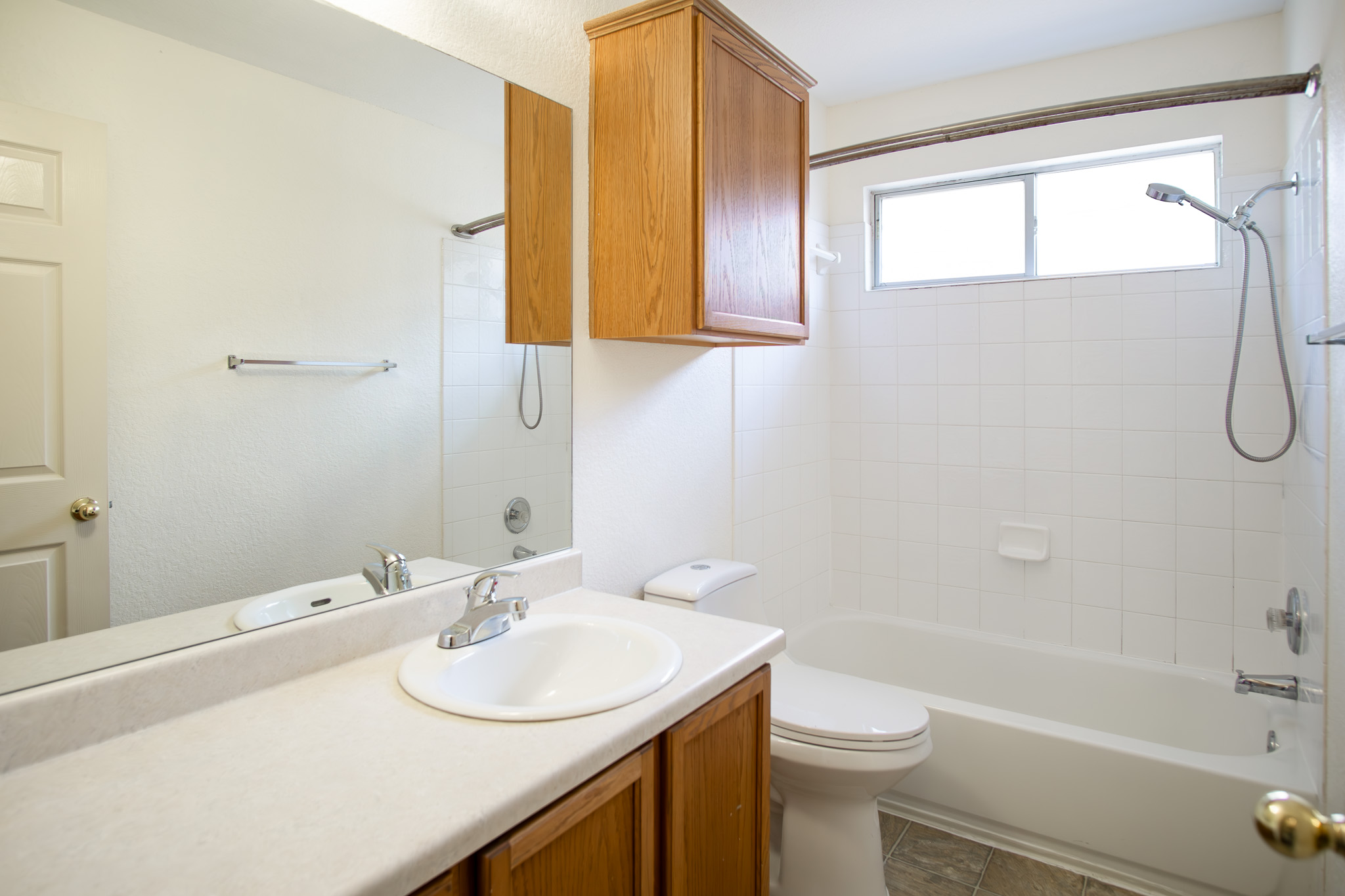 9312 Rowlands Sayle Road Austin, TX 78744 - Photo 9 of 13 Functional bathroom layout features a classic tub-shower combo and a wood vanity setup.