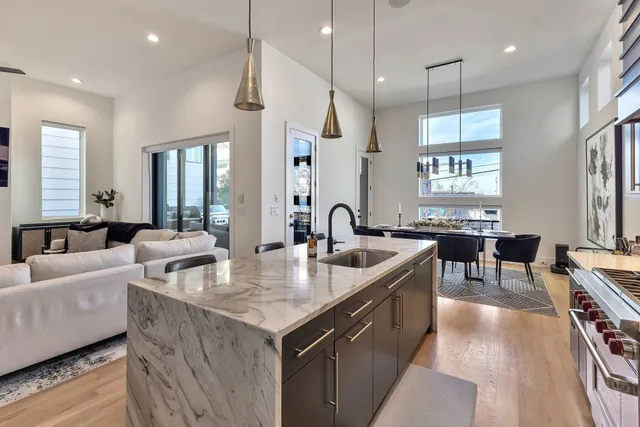a large kitchen with sink a counter top space and living room view