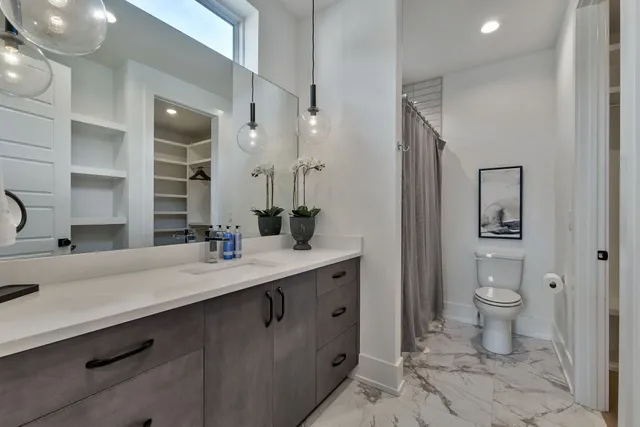 a spacious bathroom with a double vanity sink toilet and shower