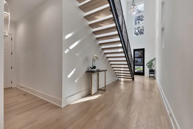 a view of a hallway with wooden floor and stairs