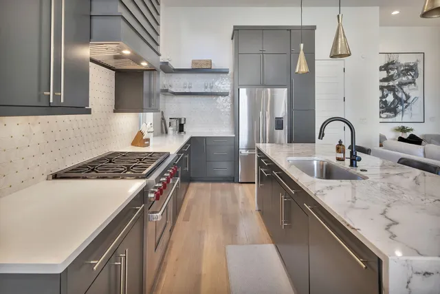a kitchen with kitchen island a sink stove and refrigerator