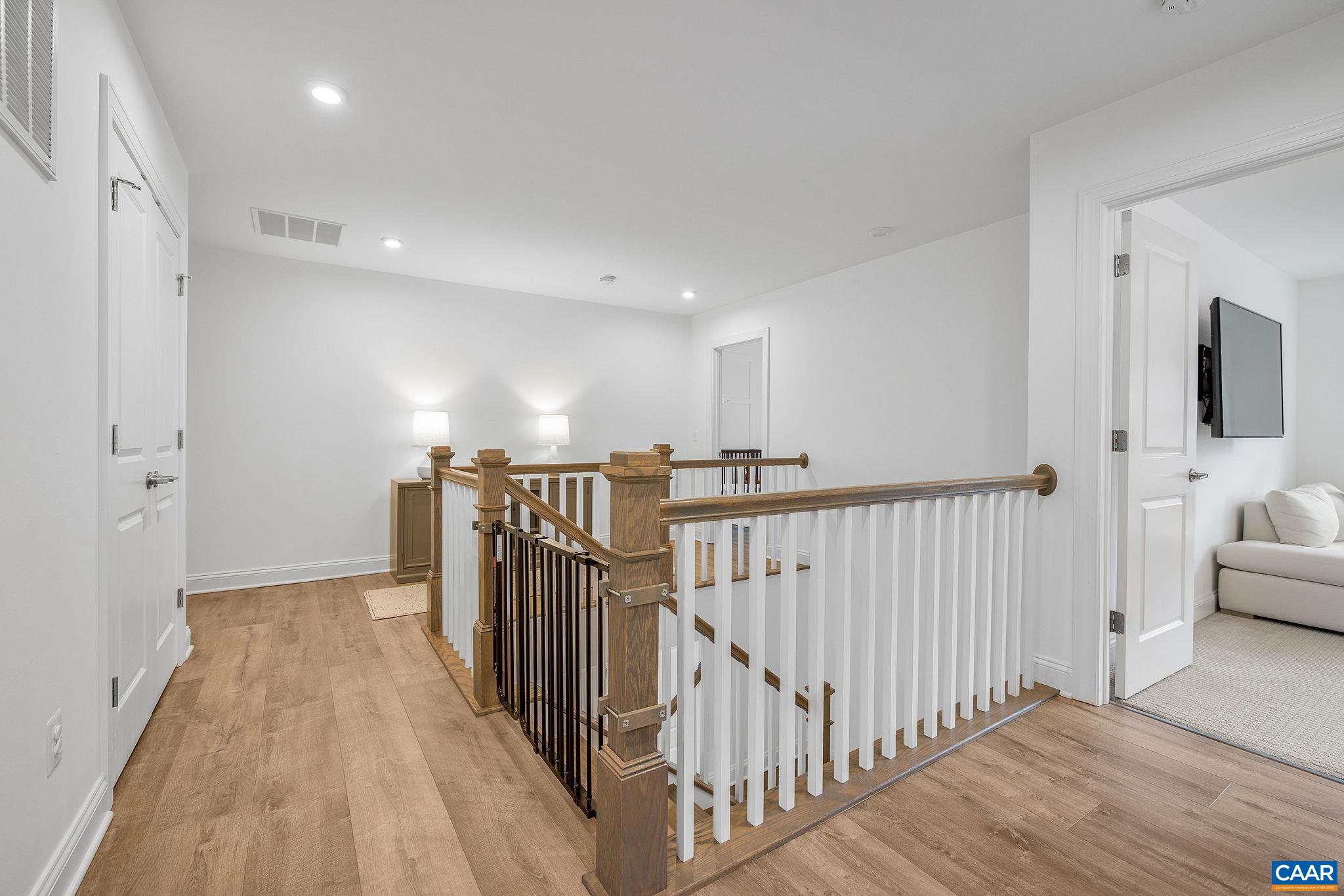 116 Paynes Mill Road Charlottesville, VA 22902 - Photo 39 of 60 a view of a hallway with a livingroom with wooden floor and stairs