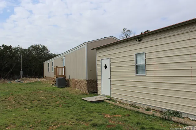 a backyard of a house with table and chairs