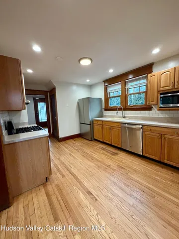 a large kitchen with stainless steel appliances granite countertop a stove a sink and a refrigerator