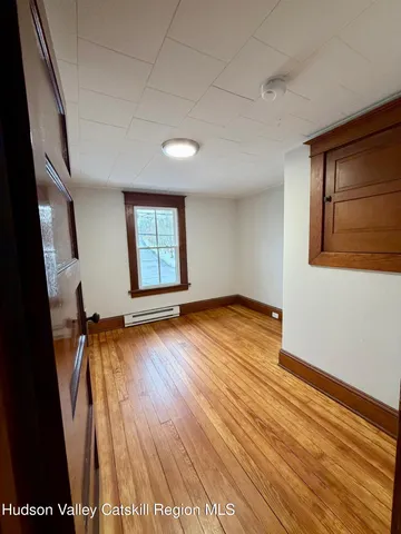 an empty room with wooden floor and door