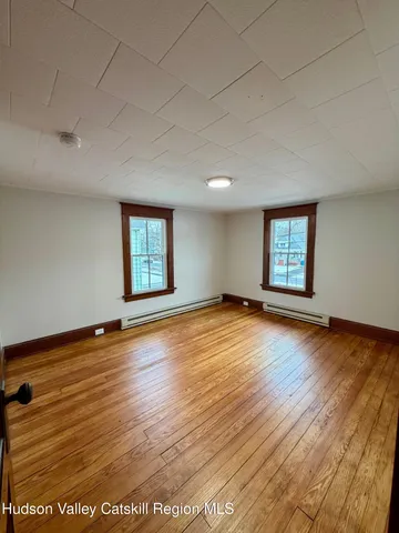 an empty room with wooden floor and window