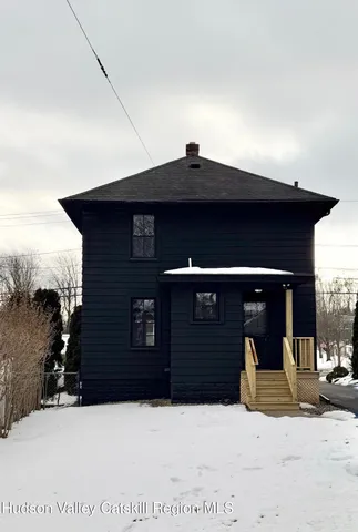 a black and white building with a large tree