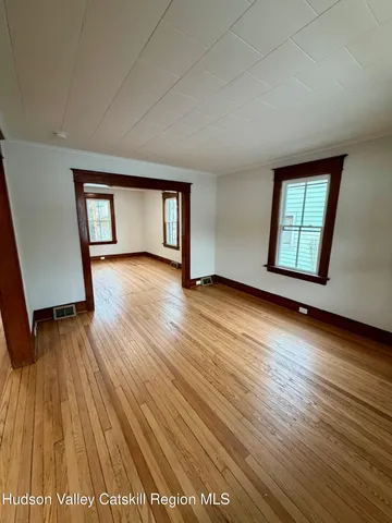 an empty room with wooden floor and a window