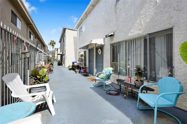 a living room with patio furniture and potted plants