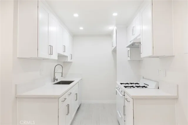 a kitchen with kitchen island a sink a stove and refrigerator