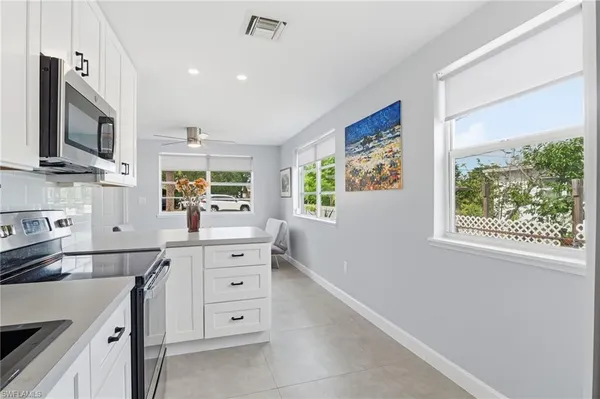 a kitchen with cabinets stainless steel appliances a sink and a window