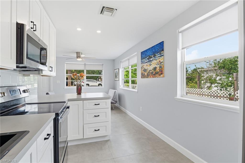 4518 West Alhambra Circle Naples, FL 34103 - Photo 16 of 40 a kitchen with cabinets stainless steel appliances a sink and a window