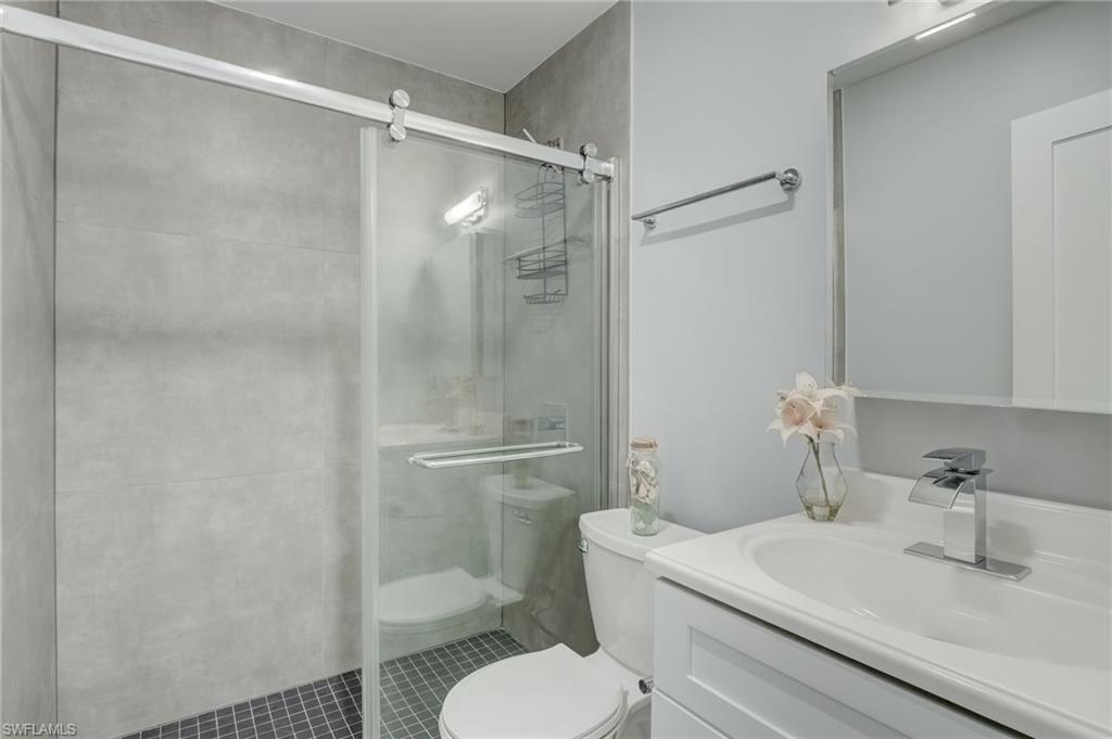 4518 West Alhambra Circle Naples, FL 34103 - Photo 9 of 40 a bathroom with a sink toilet and shower