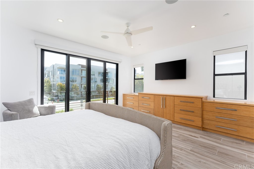 237 1st Street Huntington Beach, CA 92648 - Photo 17 of 68 a bedroom with a large bed and a flat tv screen on dresser