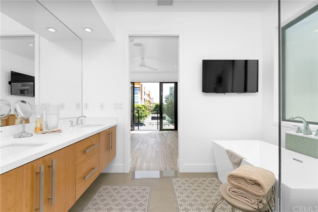 237 1st Street Huntington Beach, CA 92648 - Photo 25 of 68 a spacious bathroom with a double vanity sink a mirror and a bathtub