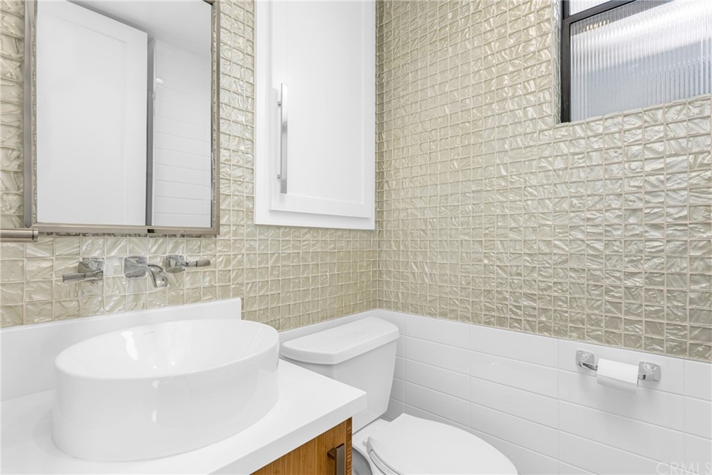 237 1st Street Huntington Beach, CA 92648 - Photo 39 of 68 a bathroom with a sink a toilet and mirror