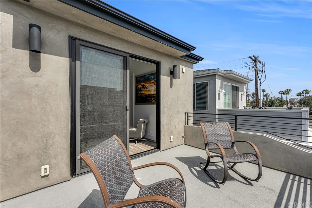 237 1st Street Huntington Beach, CA 92648 - Photo 45 of 68 a view of a patio with table and chairs with wooden floor and fence