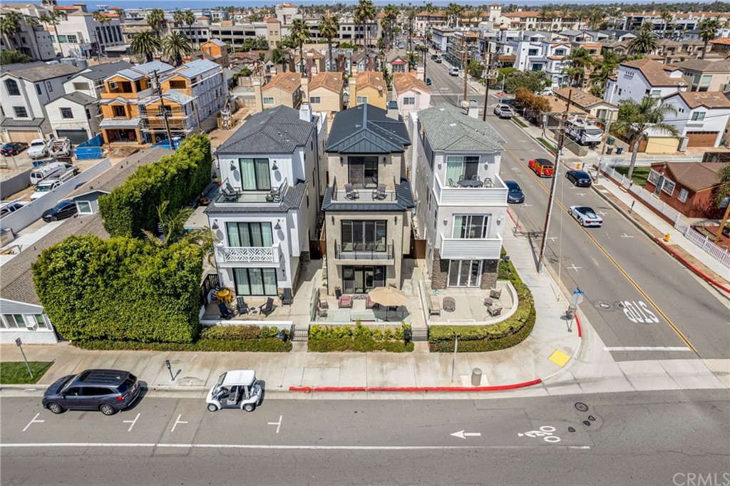 237 1st Street Huntington Beach, CA 92648 - Photo 58 of 68 a front view of a residential apartment building with a yard and parking spaces