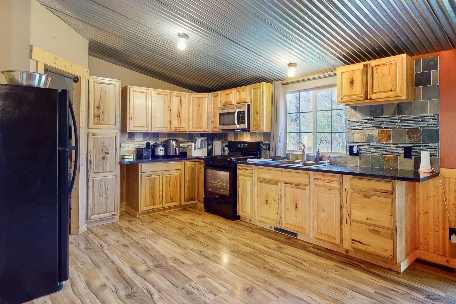 10146 Frenchtown Dobbins Road Dobbins, CA 95935 - Photo 5 of 38 a kitchen with stainless steel appliances granite countertop a refrigerator a sink dishwasher a stove with wooden cabinets and floor