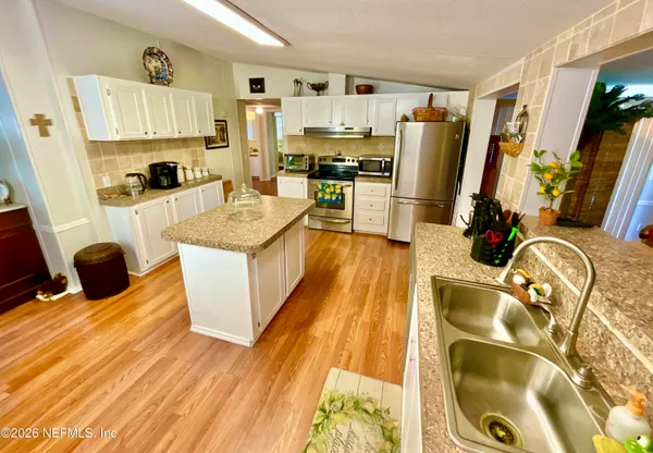 a kitchen with stainless steel appliances a stove a sink a refrigerator and cabinets