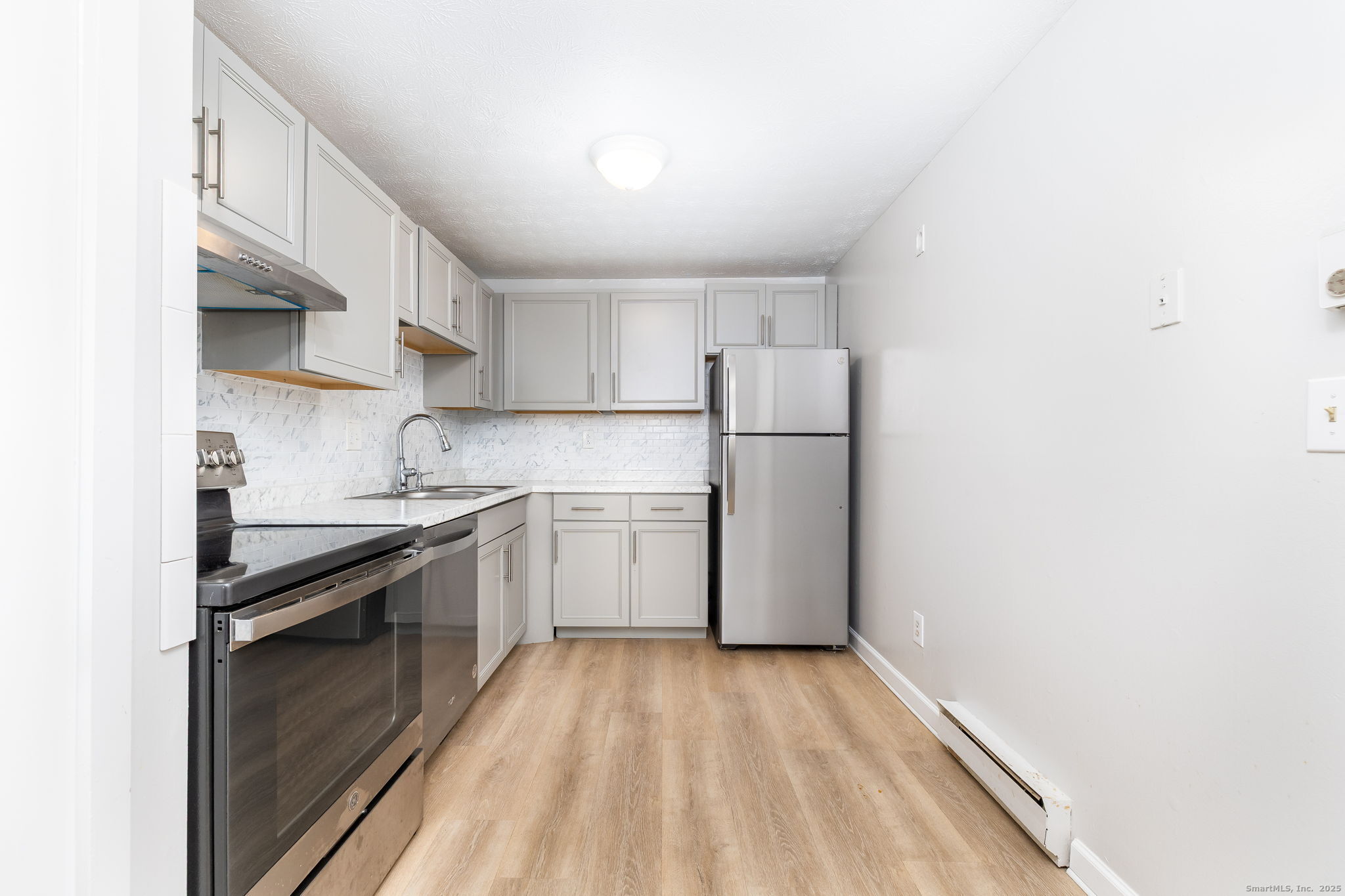 949 Pleasant Valley Road, Unit 801 South Windsor, CT 06074 - Photo 3 of 22 a kitchen with a sink a refrigerator and cabinets