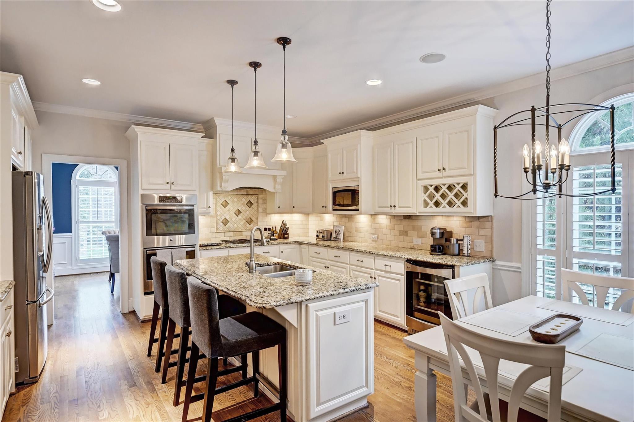 6009 Sharon View Road Charlotte, NC 28226 - Photo 16 of 47 a kitchen with stainless steel appliances kitchen island granite countertop a table chairs stove and white cabinets