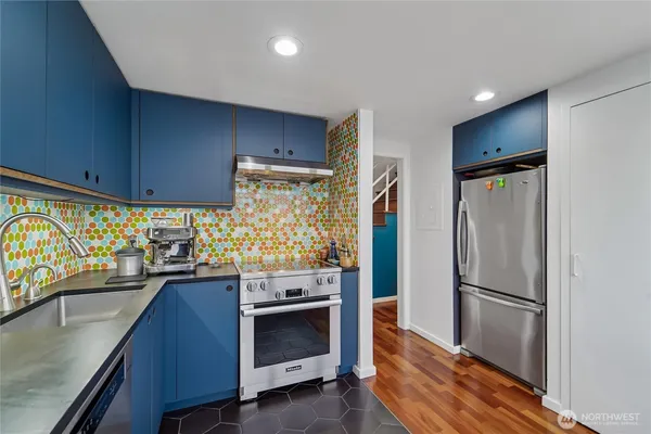 a kitchen with stainless steel appliances a stove refrigerator sink and cabinets