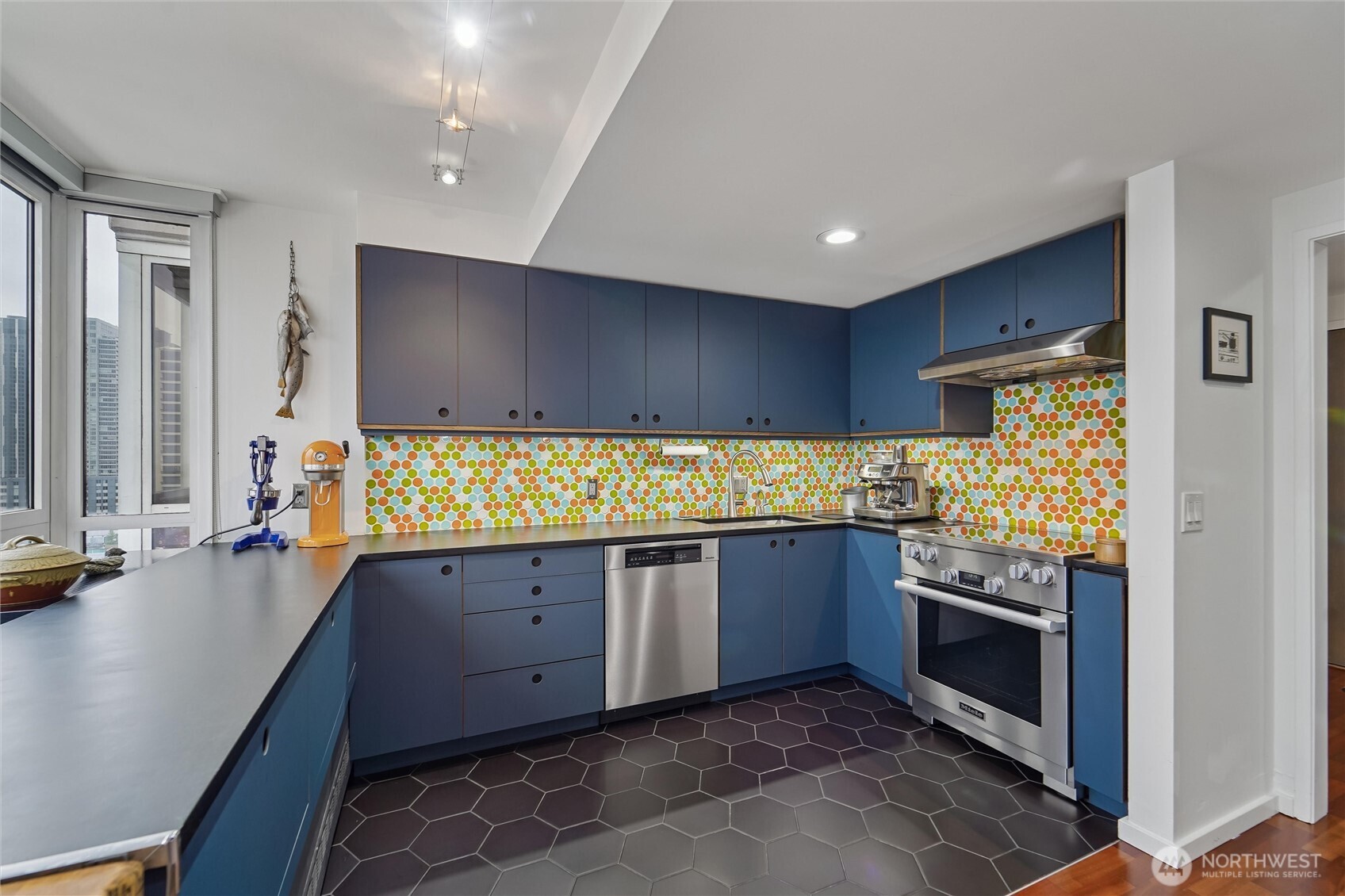 2125 1st Avenue, Unit 1702 Seattle, WA 98121 - Photo 13 of 26 a kitchen with stainless steel appliances granite countertop wooden cabinets and sink