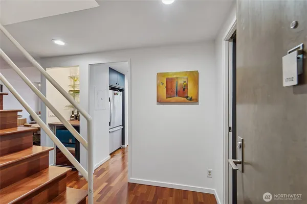 a view of staircase with wooden floor and paintings on the walls