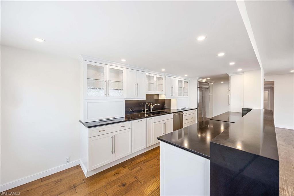 1325 7th Street South, Unit 2B Naples, FL 34102 - Photo 12 of 34 a kitchen with stainless steel appliances granite countertop a sink and cabinets