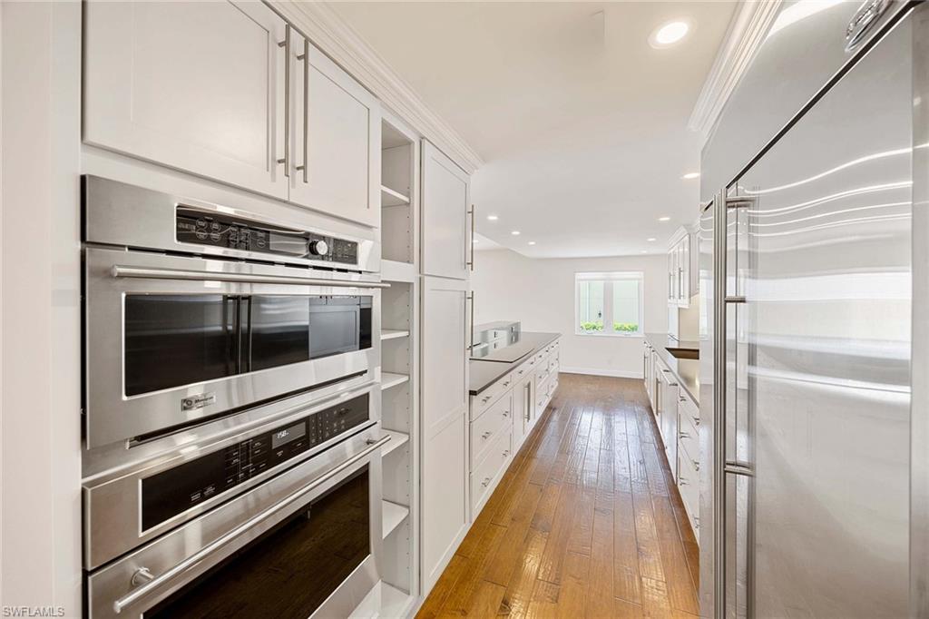 1325 7th Street South, Unit 2B Naples, FL 34102 - Photo 13 of 34 a kitchen with white cabinets and stainless steel appliances