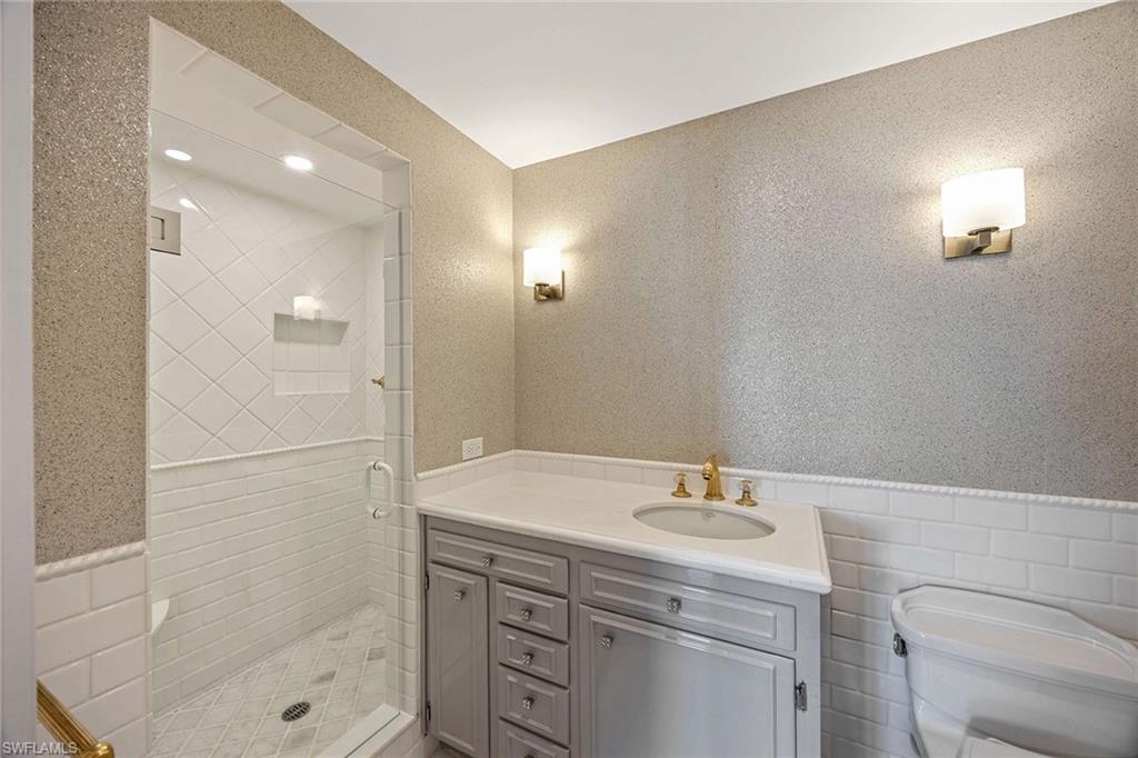 1325 7th Street South, Unit 2B Naples, FL 34102 - Photo 20 of 34 a bathroom with a shower sink vanity and mirror