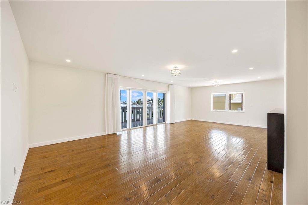 1325 7th Street South, Unit 2B Naples, FL 34102 - Photo 8 of 34 a view of an empty room with wooden floor and a window