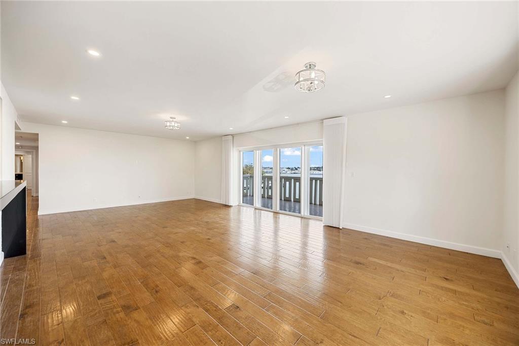 1325 7th Street South, Unit 2B Naples, FL 34102 - Photo 10 of 34 a view of an empty room with wooden floor and a window