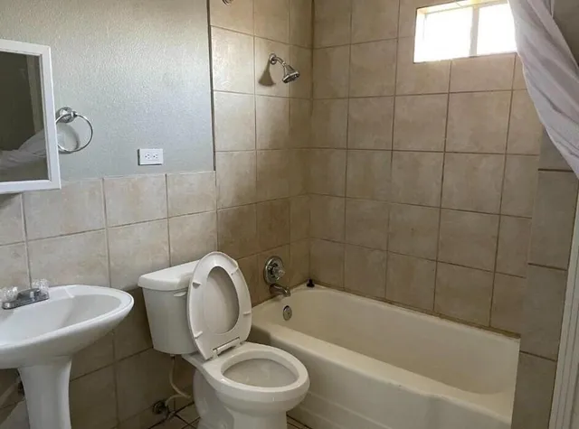 a bathroom with a toilet a sink and bathtub