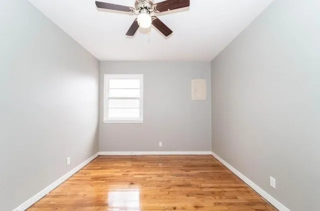 a view of empty room with wooden floor