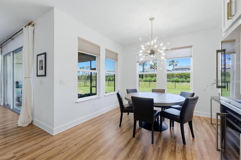 8498 Snowfall Street Sarasota, FL 34241 - Photo 24 of 95 a view of a dining room with furniture a chandelier and wooden floor