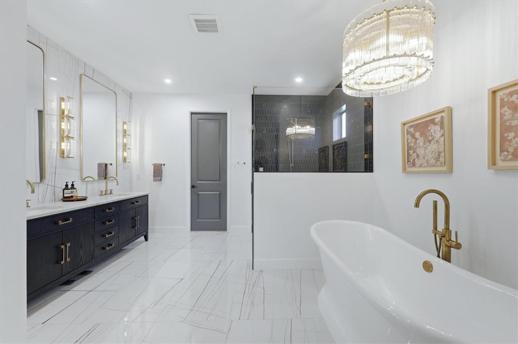 8498 Snowfall Street Sarasota, FL 34241 - Photo 37 of 95 a spacious bathroom with a double vanity sink shower and a mirror