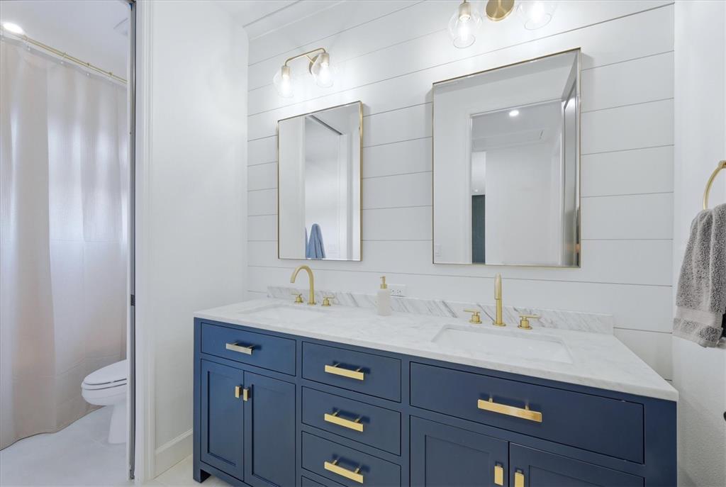8498 Snowfall Street Sarasota, FL 34241 - Photo 48 of 95 a bathroom with a granite countertop sink a toilet and a mirror
