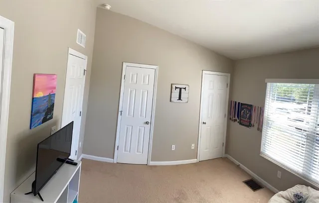 a view of an empty room with window and workspace