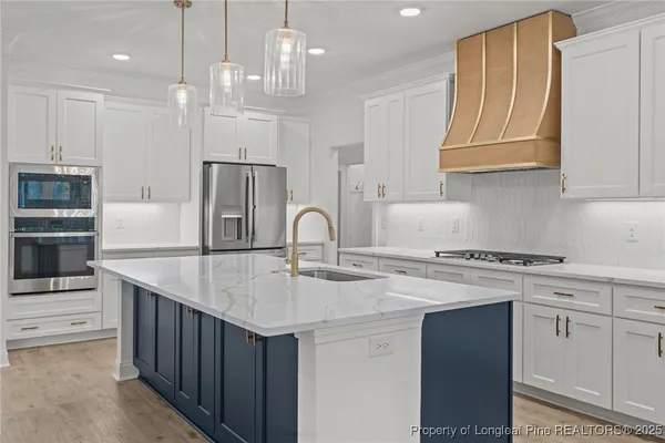 a kitchen with stainless steel appliances a sink a stove a refrigerator and cabinets