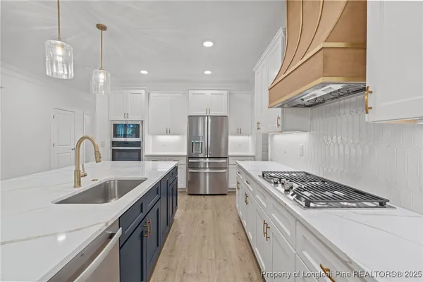 a kitchen with a sink a kitchen island wooden cabinets and stainless steel appliances