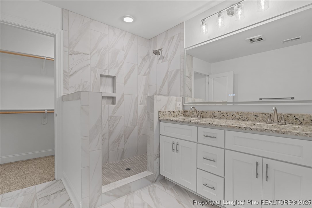 45 Pine Hill Court Spring Lake, NC 28390 - Photo 28 of 40 a bathroom with a granite countertop sink two mirror and shower