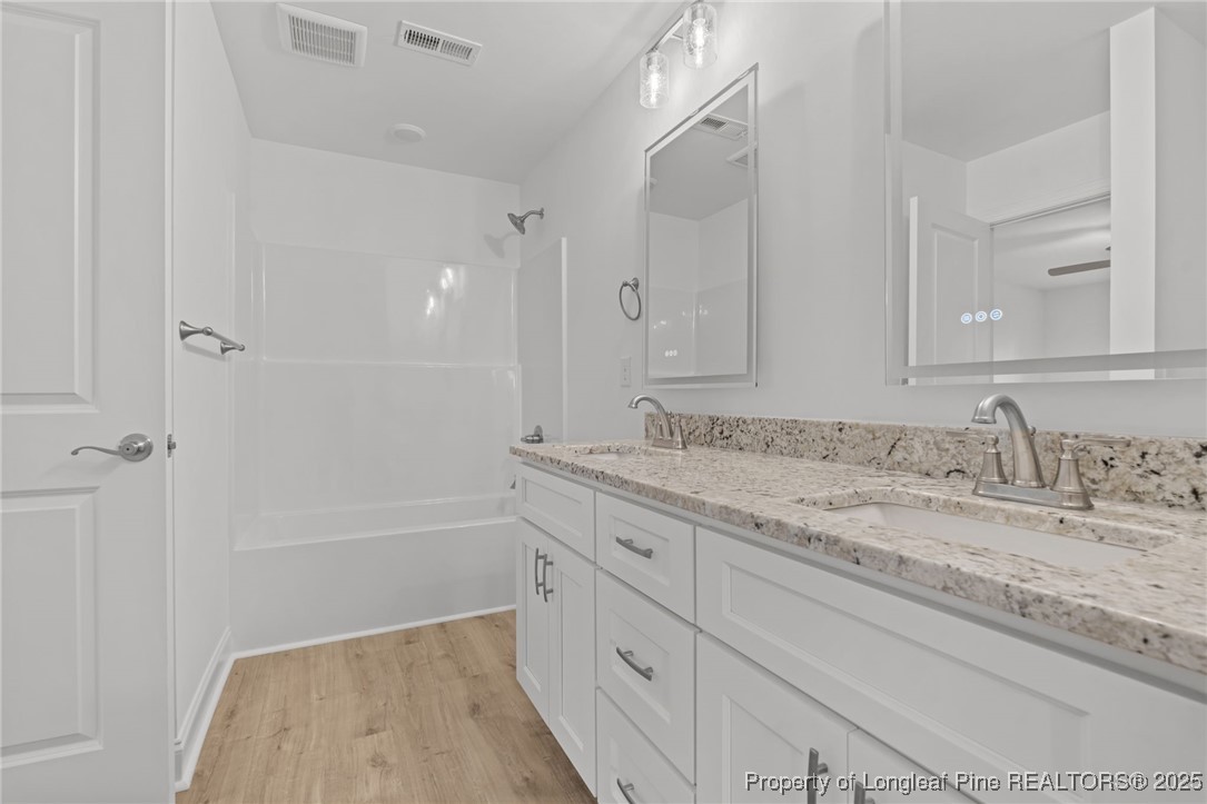 45 Pine Hill Court Spring Lake, NC 28390 - Photo 31 of 40 a bathroom with a granite countertop sink a mirror and a bathtub