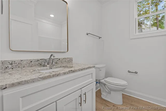 a bathroom with a granite countertop toilet sink and mirror